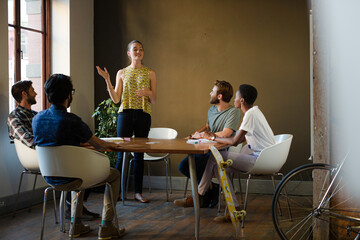 Casual business people meeting in circle in sunny office