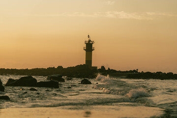 Fototapeta premium The rising sea and the colored lighthouse