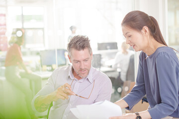 Obraz premium Business people reviewing paperwork at desk in office
