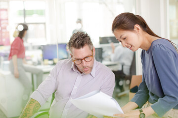 Business people reviewing paperwork at desk in office