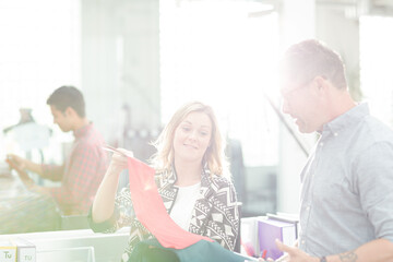 Fototapeta premium Fashion designers discussing fabric swatch in sunny office