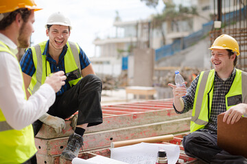 Construction worker engineer clipboard talking at highrise construction site