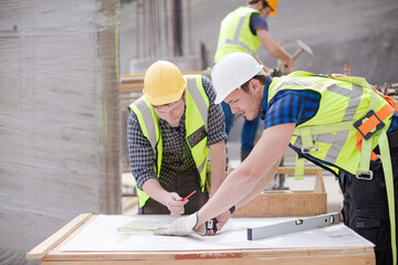 Construction worker engineer reviewing blueprints at construction site