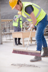 Construction worker sweeping at construction site