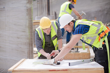 Construction worker engineer reviewing blueprints at construction site