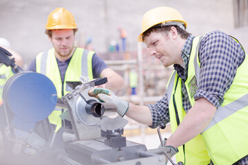 Construction workers adjusting metal bar at construction site