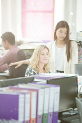 Fashion designers talking at desk in office