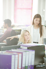 Fashion designers talking at desk in office
