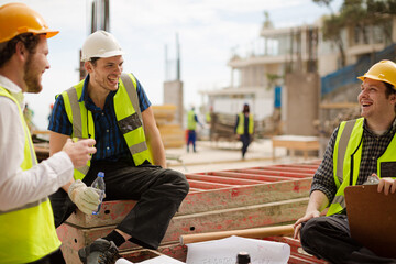 Construction worker engineer clipboard talking at highrise construction site