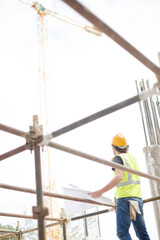 Engineer reviewing blueprints at high rise construction site