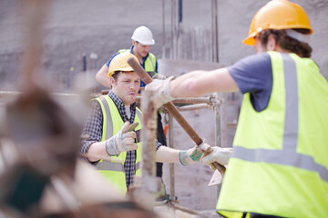 Constructor workers assembling rebar structure at construction site