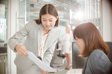 Business people reviewing paperwork at desk in office