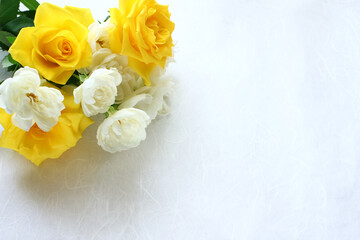 photo of a bouquet of yellow and white roses in the corner.