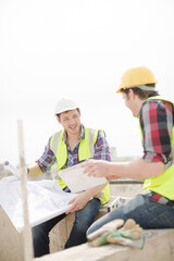 Construction worker engineer reviewing blueprints at highrise construction site