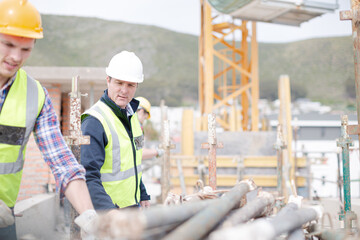 Construction worker carrying metal bar at construction site