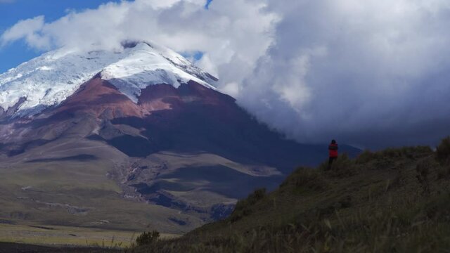 Photographer with red jacket in landscape of Cotopaxi volcano, Ecuador. South America Highlands.