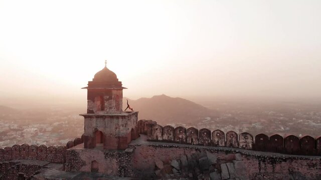 Opposite Amer fort in Jaipur is a watch tower situated, Shot this with the drone at the sunrise. Overlooking the city of Jaipur in India.