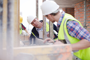 Construction worker engineer digital tablet talking at construction site