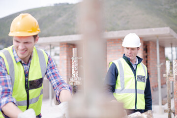 Construction worker carrying metal bar at construction site