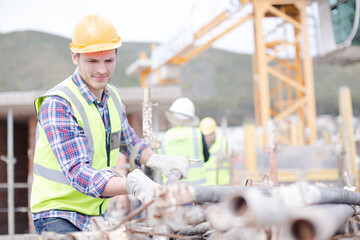 Construction worker carrying metal bar at construction site