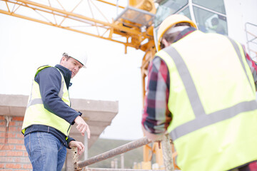 Constructor workers assembling rebar structure at construction site