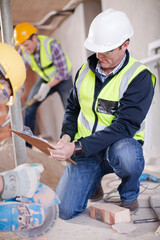Construction worker cutting brick