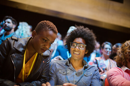 Man and woman with with smart phone in conference audience