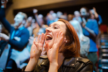 Smiling, enthusiastic woman cheering in audience