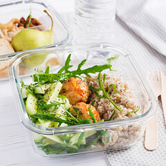 Lunch box filled with oatmeal, cucumber salad, and nuts, bread, pear on white wooden background. Lunchbox dinner.