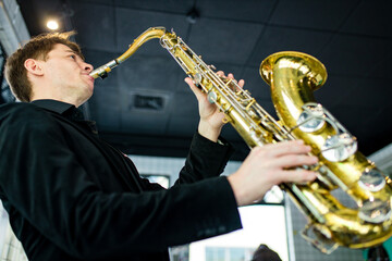 Male jazz musician playing a saxophone in a restaurant
