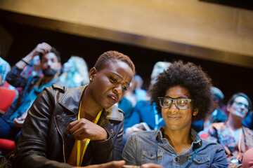 Man and woman with with smart phone in conference audience