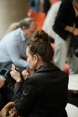 Woman applying make up in hall of auditorium