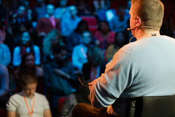 Fototapeta na wymiar Audience watching male speaker in wheelchair talking on stage