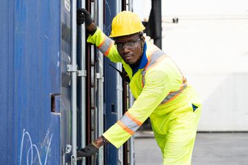 Worker and people concept, Male worker in uniform and wearing safety yellow helmet while working on commercial dock site with container box from cargo freight ship for import export