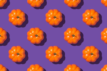 Top view closeup photo of orange pumpkins on isolated violet background