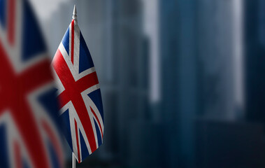 Small flags of United Kingdom on a blurry background of the city - 455866072