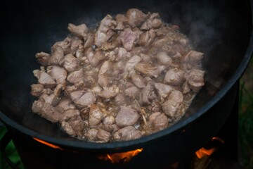 Lamb is fried in a cauldron with onions.