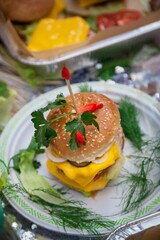 A large fresh burger with a cutlet, cheese, salad and sauce.