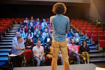 Male speaker on stage talking to audience