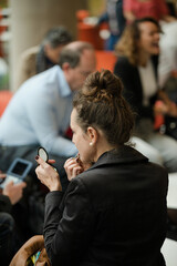 Woman applying make up in hall of auditorium