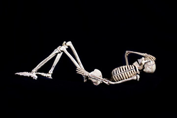 Sleeping Skeleton bones on dark background, Resting skull after party
