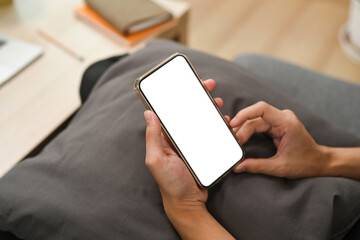 Close up view man using smart phone and sitting on couch.