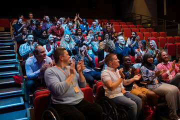 Audience clapping in dark room