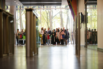 People entering auditorium hallway