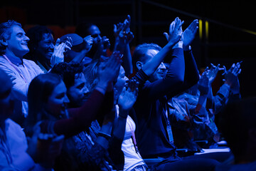 Enthusiastic audience clapping and cheering