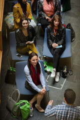 Audience watching male speaker with arms outstretched on stage