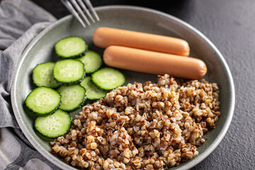 buckwheat porridge with sausages and cucumber salad fresh portion ready to eat meal snack on the table copy space food background rustic. top view keto or paleo diet