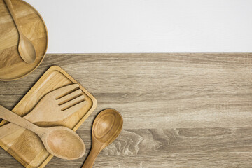 wooden kitchen utensils on wooden and white background