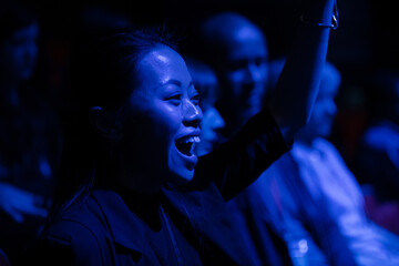 Smiling, enthusiastic woman cheering in audience