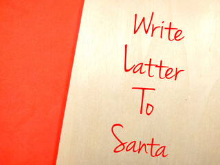 Text Write Latter To Santa writing on wooden board on a red background.